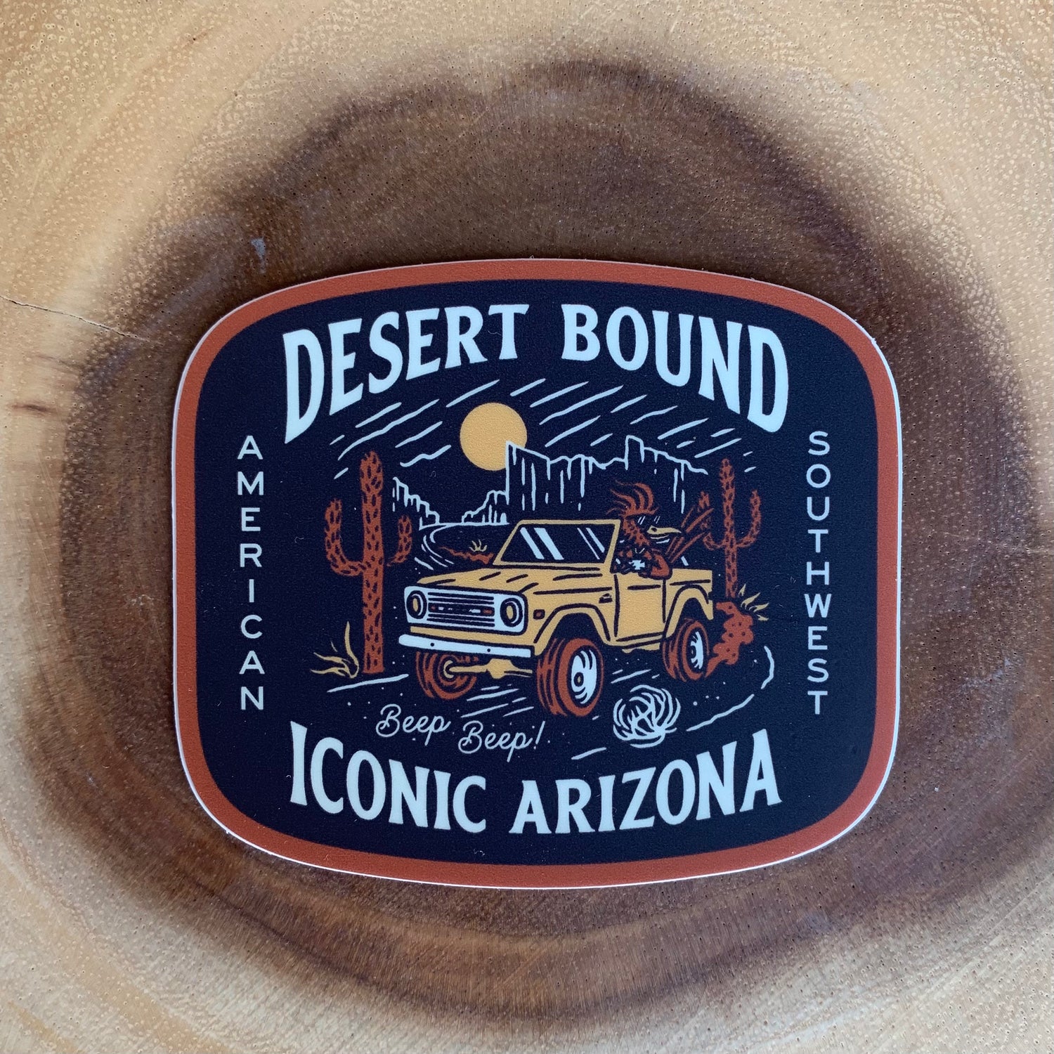 Desert Bound sticker edge with bold white letters on a dark background and orange border.